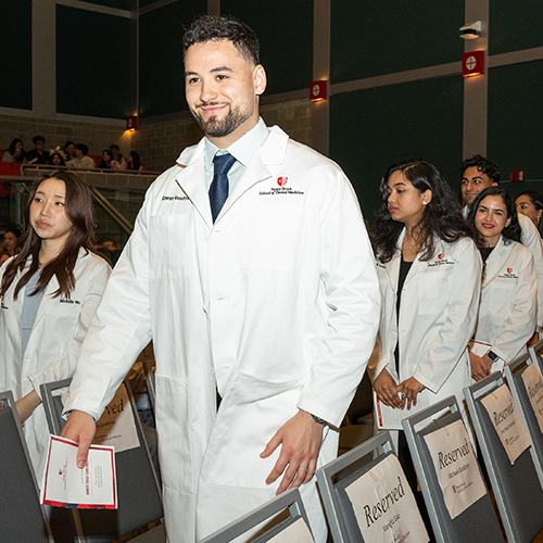 Students file out after being fit for their white coats