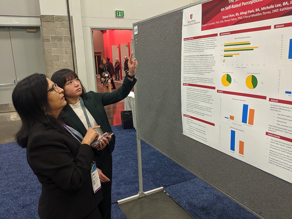 DDS student Dana Chan presenting her research to a visitor at the ADEA annual meeting in Portland, Oregon.