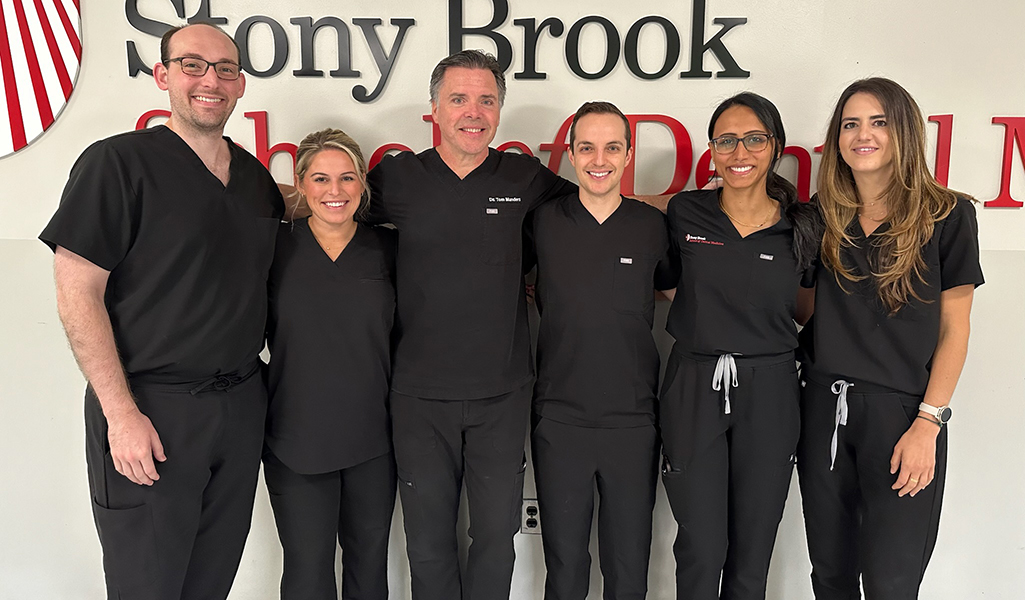 2024-25 Stony Brook endodontics residents standing with program director Thomas Manders