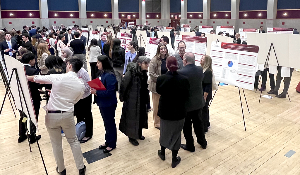 A wide-angle image of Research Day, with presenters and visitors filling a large ballroom
