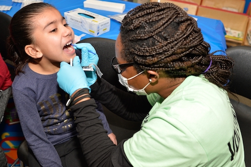 Dr. Roxanne Clarke, DCDD Fellow, Provides Dental Care to Child