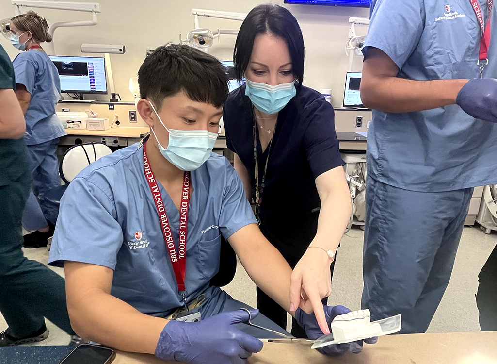 Discover Dental School student with mentor working in a laboratory setting Discover Dental School student with mentor working in a laboratory setting