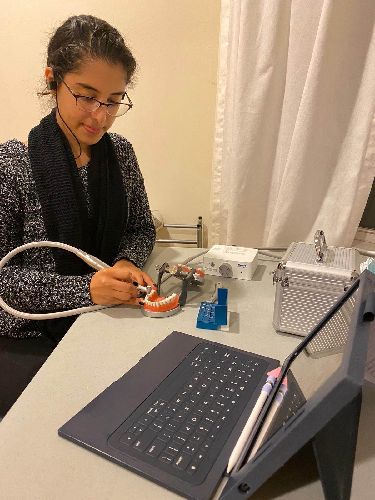 A Stony Brook School of Dental Medicine student uses an electric hand piece for virtual instruction.