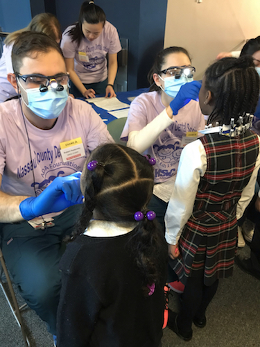 Children receive free oral health screenings from Stony Brook School of Dental Medicine students in Garden City, New York