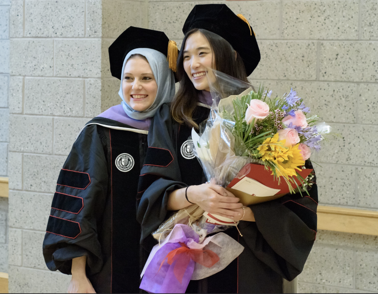 Two Class of 2019 students pose following the 43rd annual Commencement Ceremony of Stony Brook University School of Dental Medicine