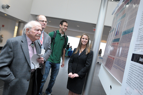 Dr. Sreebny Views a Research Poster at the 2017 Leo and Mickey Sreebny Symposium