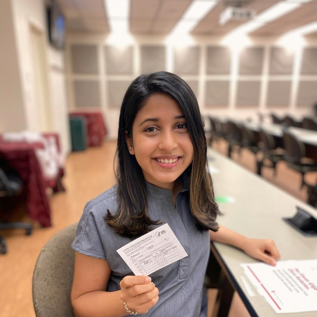 Stony Brook School of Dental Medicine student displays proof of vaccine card.