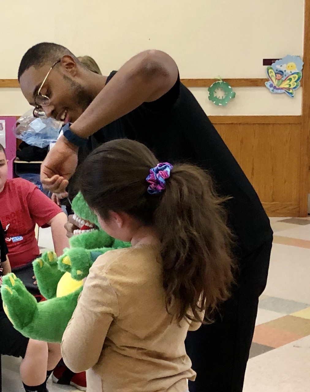 Dr. Sean Challenger of Stony Brook School of Dental Medicine shows oral hygiene techniques to a child at a local school district.