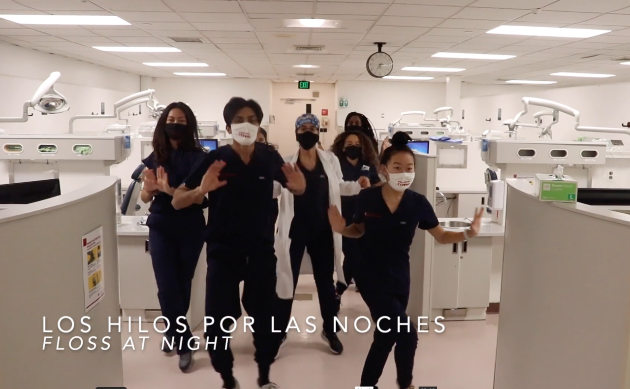 Screen shot from video of Stony Brook School of Dental Medicine students dancing in scrubs in the dental clinic. 