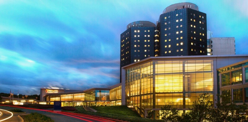 Photo Stony Brook University Hospital lit up at night with dark sky behind it